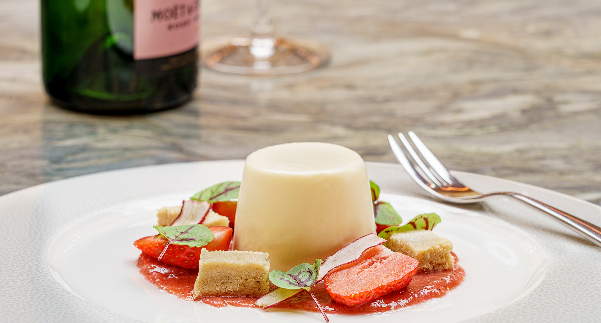 Panacotta pudding served with pieces of strawberries and shortbread