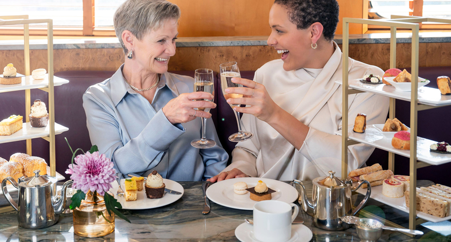 Mother and daughter raise a glass of Champagne to each other during Afternoon Tea