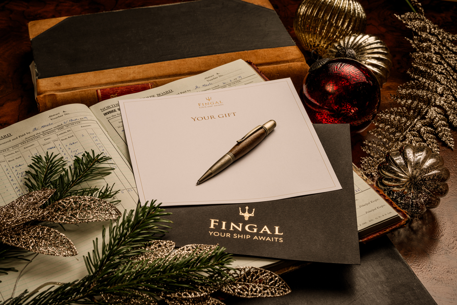 Edinburgh hotel gift voucher with pen and Christmas decorations, reading Fingal You Ship Awaits