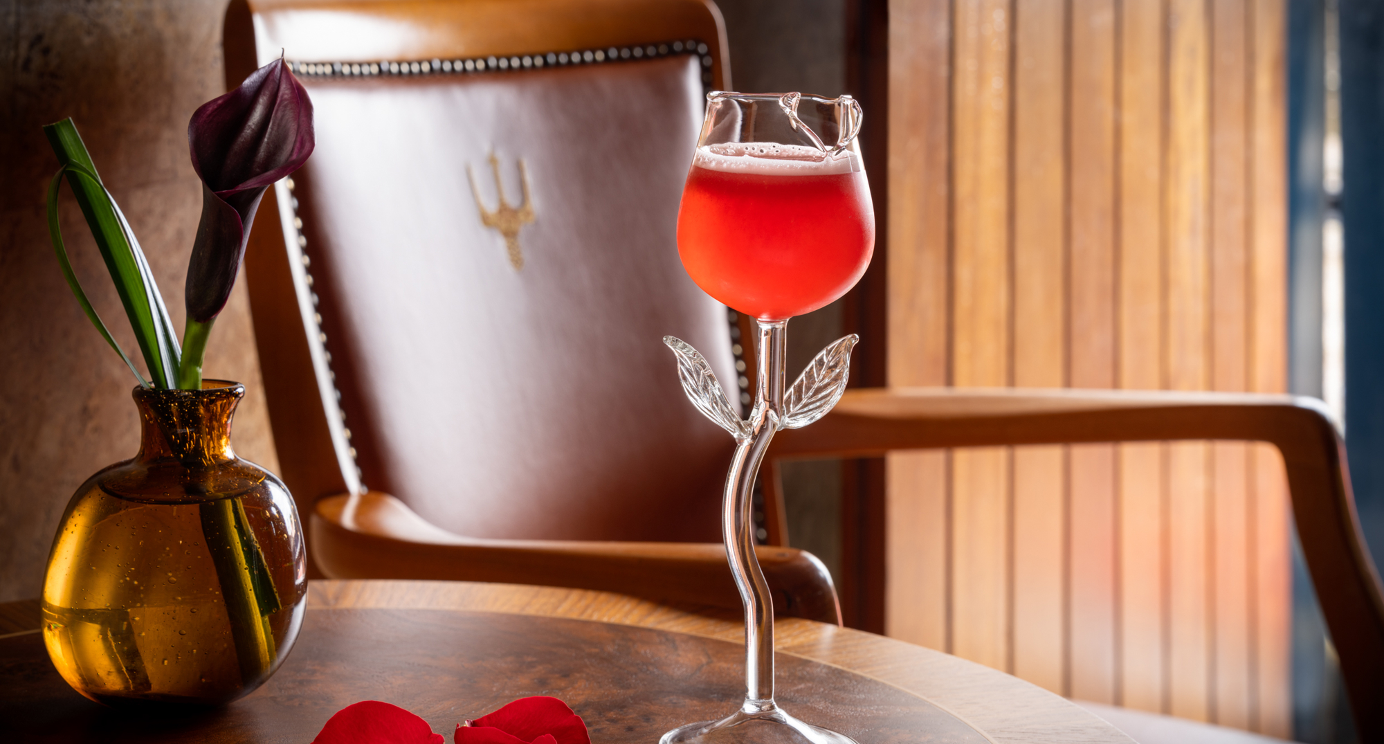 A red drink served in a rose shaped glass on a table at Fingal Hotel. 