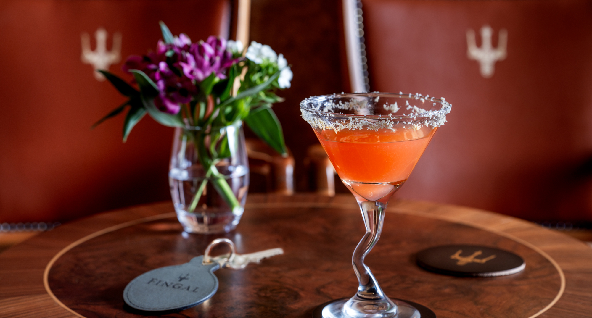 An orange coloured cocktail in a glass with a frosted rim at Fingal Hotel. 