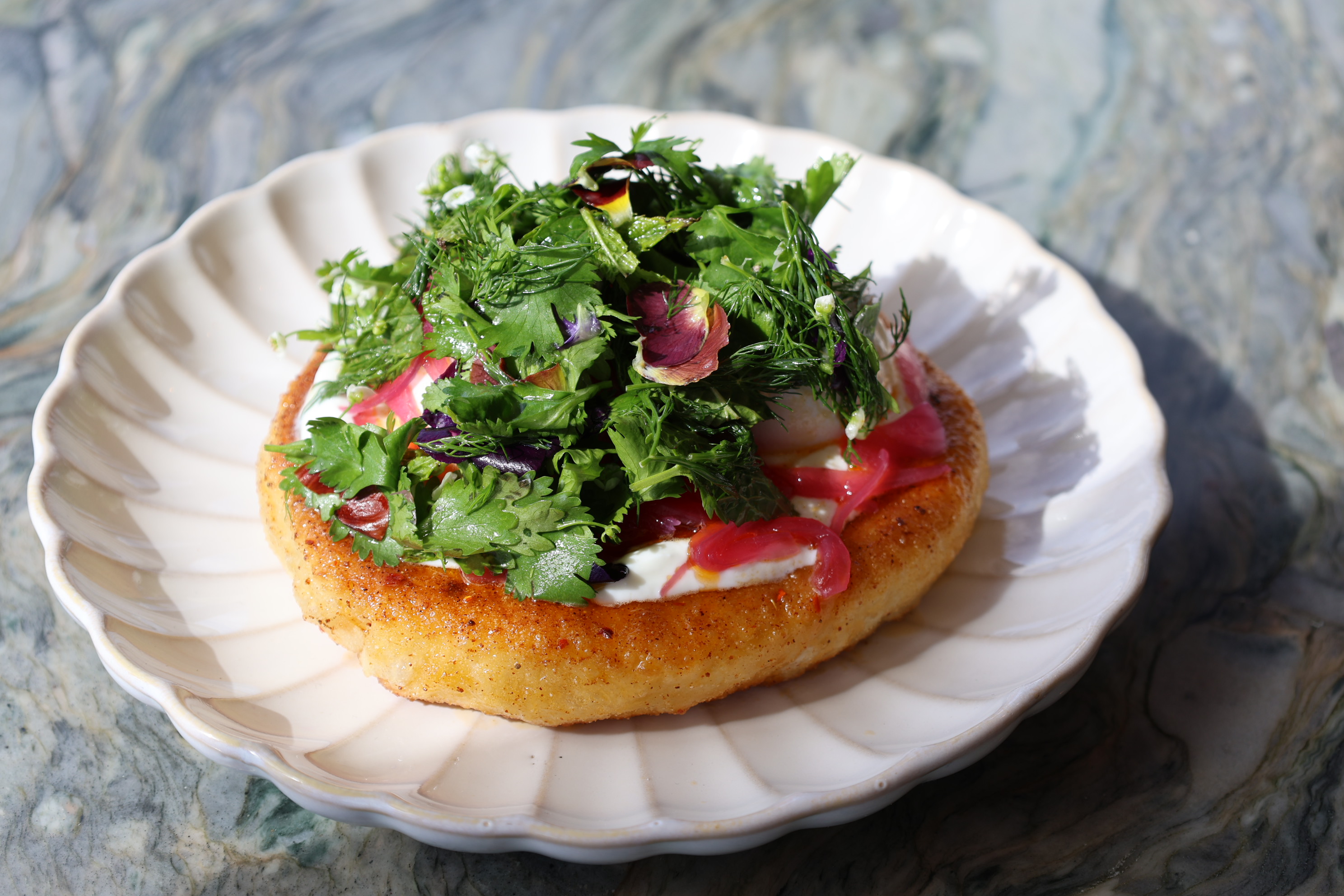 A plate with Turkish Egg dish in the sunshine on a table. 