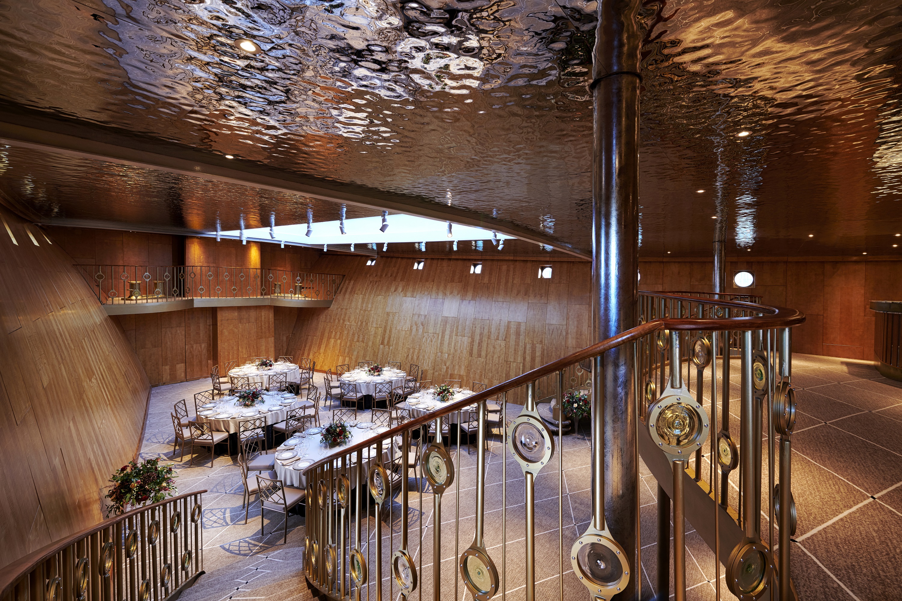 Ballroom looking from the top of a staircase as the stairs cascades down the the right. 